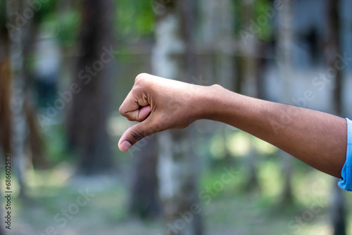 A man's hands are fists and the old man is pointing the finger down and blurred background © Rokonuzzamnan