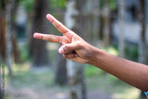 Two fingers of a man's hand pointing forwards and blurred background © Rokonuzzamnan