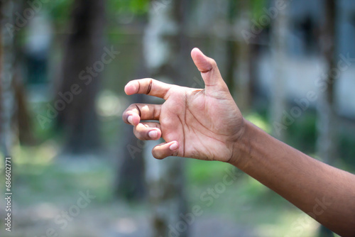 A human hand showing five fingers and a blurred background © Rokonuzzamnan