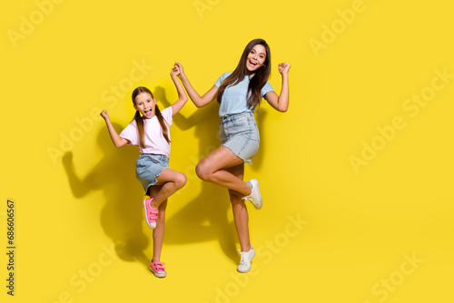 Photo of of two excited sisters raise fists winning school contests isolated over bright color background