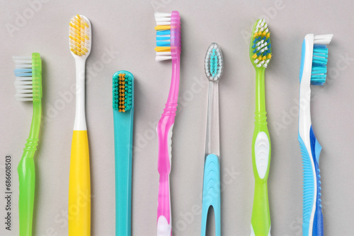 Many different toothbrushes on light background  flat lay