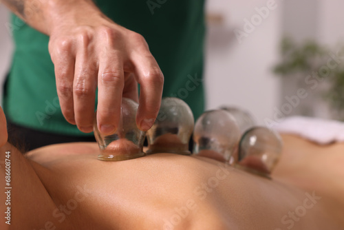 Therapist giving cupping treatment to patient indoors  closeup