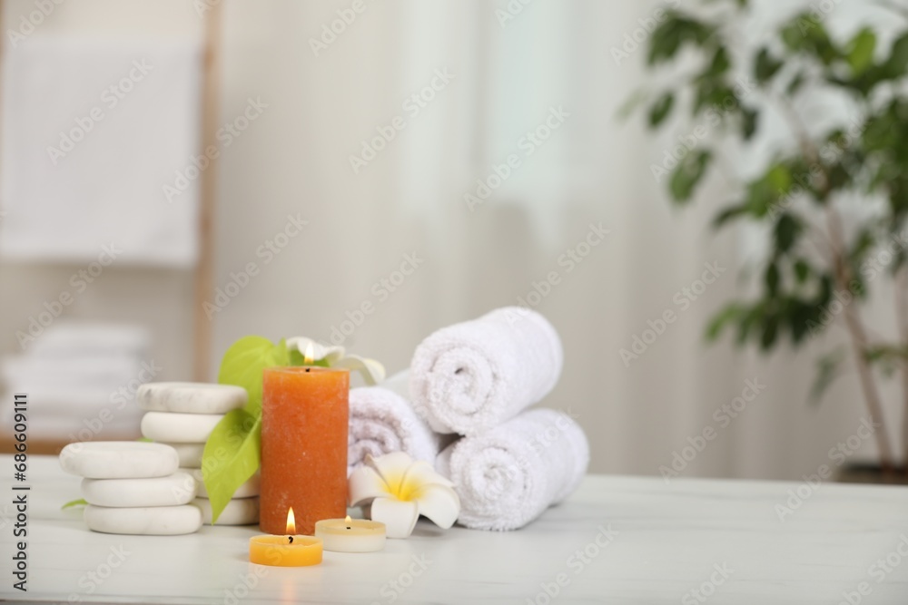 Composition with different spa products and plumeria flowers on white marble table indoors, space for text