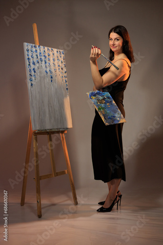 female artist paints a picture in the studio photo