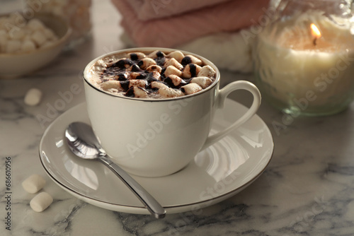 Cup of aromatic hot chocolate with marshmallows served on light marble table, closeup