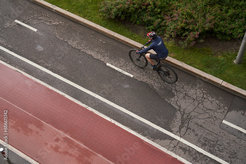 Man riding on bicycle on a bike path in the city. View from above.