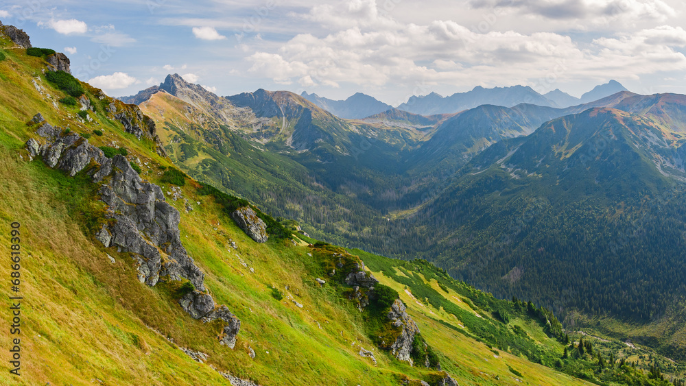 Polish Tatra Mountains, high mountain hiking trail leading to mountain peaks, mountain landscape with valleys and slopes, view on a sunny summer day.