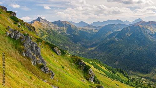 Polish Tatra Mountains, high mountain hiking trail leading to mountain peaks, mountain landscape with valleys and slopes, view on a sunny summer day.