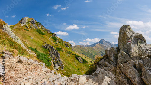 Polish Tatra Mountains, high mountain hiking trail leading to mountain peaks, mountain landscape with valleys and slopes, view on a sunny summer day. © Castigatio