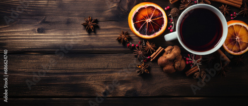 Cup of hot mulled wine with spices on wooden background. photo