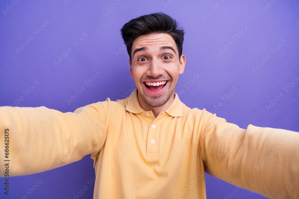 Photo of excited funky man dressed yellow shirt tacking selfie smiling isolated purple color background Photo of excited funky man dressed yellow shirt tacking selfie smiling isolated purple color background
