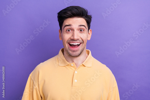 Photo of good mood impressed guy wear yellow polo smiling open mouth isolated violet color background