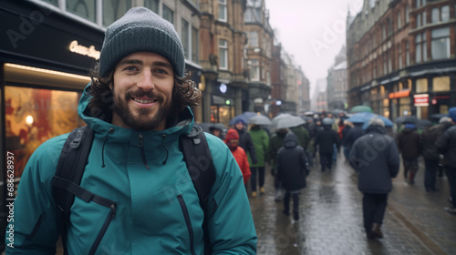 Tourist walks along a rainy street in Amsterdam during winter.