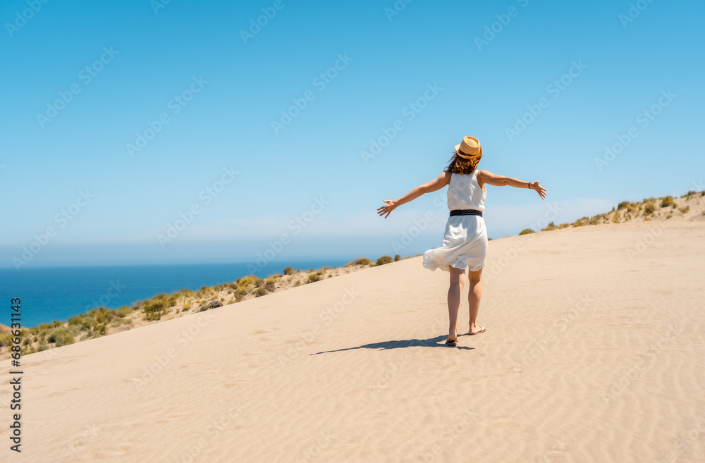 Free woman walking along a path in a windy day