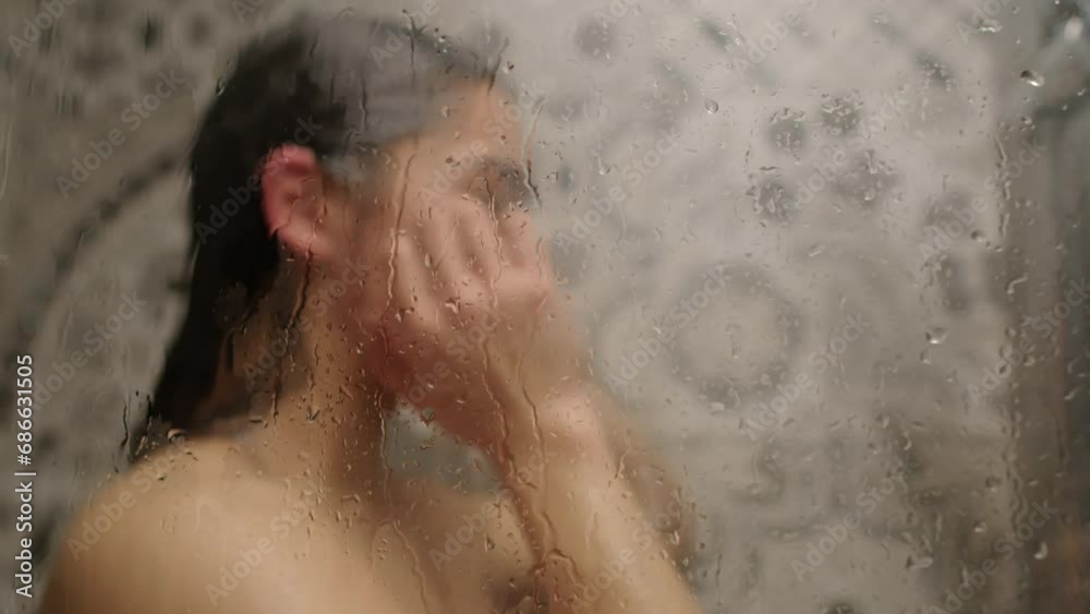 Blurred view of woman washing hair in shower at home Blurred view of woman washing hair in shower at home