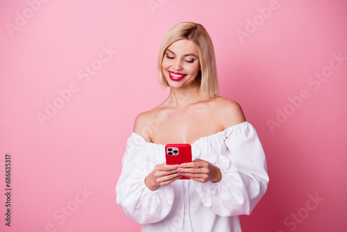 Photo of pretty sweet lady wear off shoulders dress chatting twitter telegram facebook empty space isolated pink color background