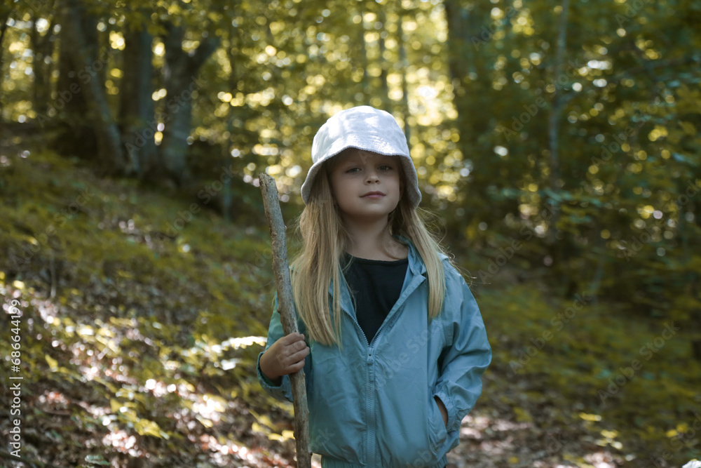Adorable little girl hiking in the forest, spending time in the nature, outdoors experience in the countryside Adorable little girl hiking in the forest, spending time in the nature, outdoors experience in the countryside
