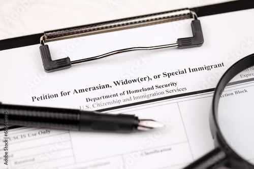 I-360 Petition for Amerasian, Widower or special immigrant blank form on A4 tablet lies on office table with pen and magnifying glass close up