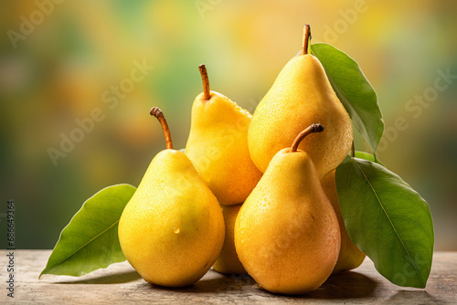 Fresh ripe pears with leaves on a wooden table with a blurred background.