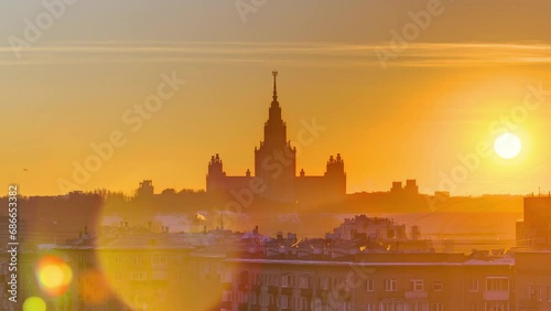Timelapse of a winter sunset over Moscow State University, captured from a top view along Komsomolskiy Avenue, with rooftops in the foreground photo