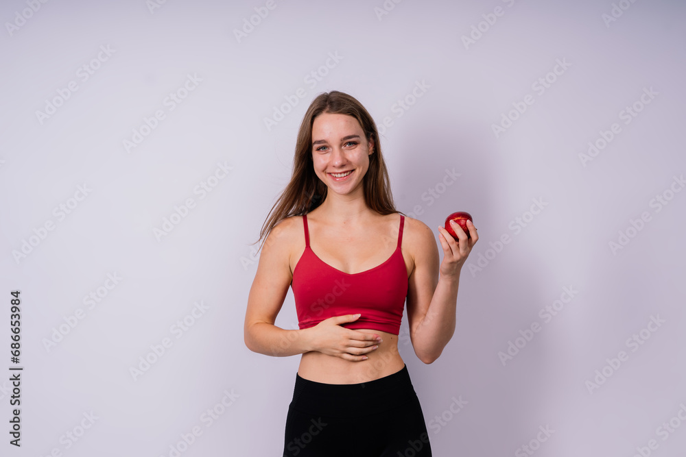 Cropped of sporty female with well fit body holding apple, healthy food and fit body concept Cropped of sporty female with well fit body holding apple, healthy food and fit body concept