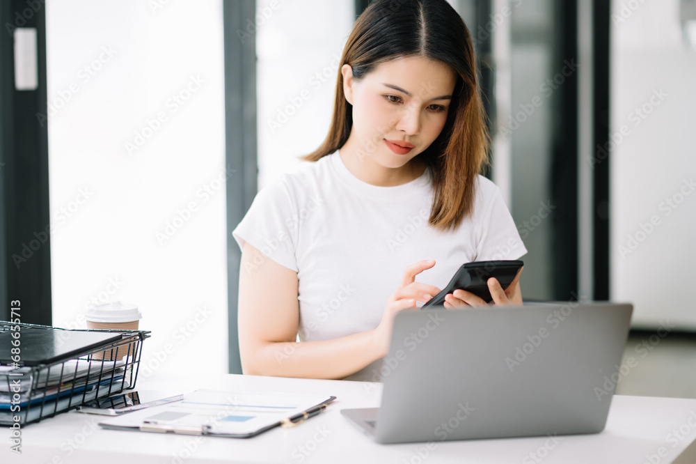 Confident Asian woman with a smile standing holding notepad and tablet at office.. Confident Asian woman with a smile standing holding notepad and tablet at office..