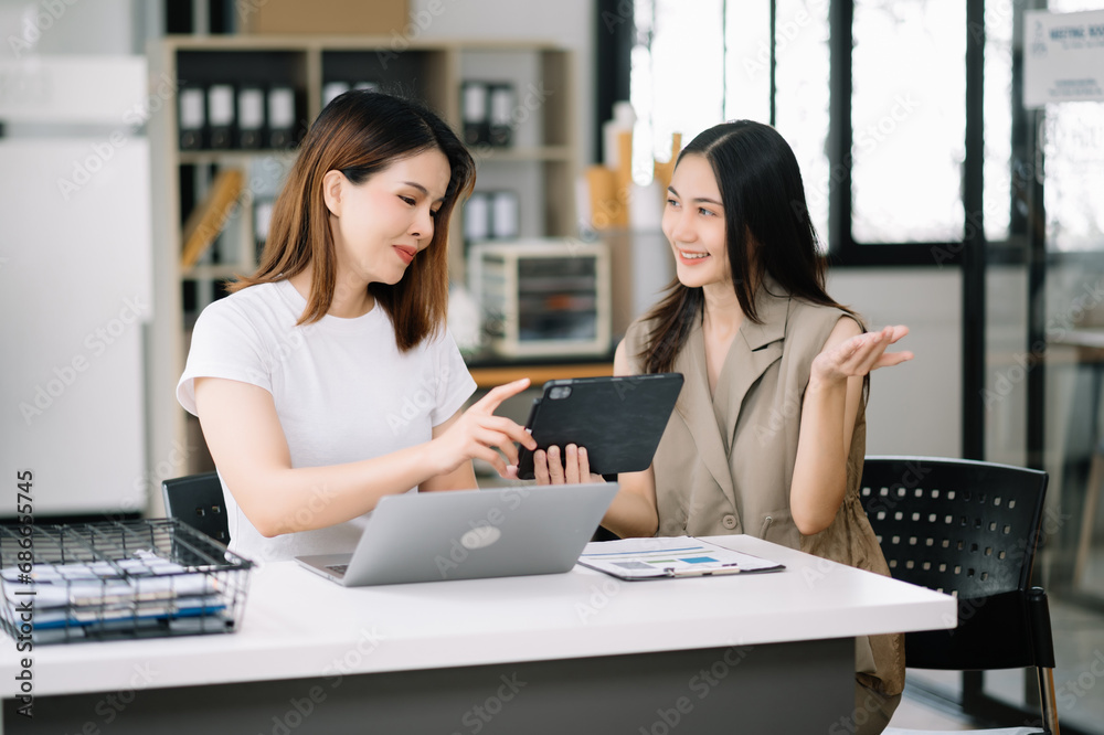 Two business workers talking on the smartphone and using laptop at the office.. Two business workers talking on the smartphone and using laptop at the office..