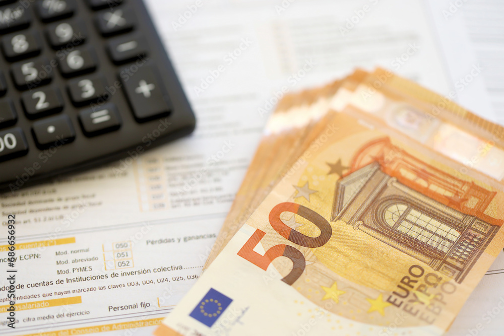 Filling italian tax form process with pen, calculator and euro money bills close up. Tax paying period and deadline Filling italian tax form process with pen, calculator and euro money bills close up. Tax paying period and deadline