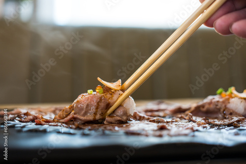 Use chopsticks eating A5 grade Japanese wagyu beef sushi. Eating wagyu beef sushi in lunch time photo