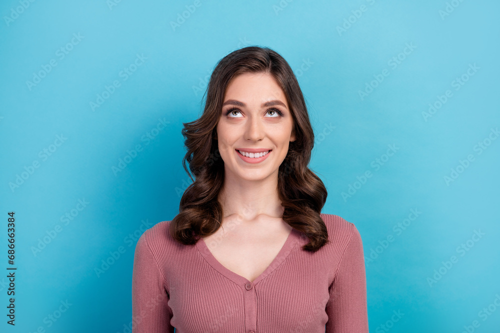 Obraz premium Portrait of toothy beaming girl with curly hairstyle wear elegant clothes look up at offer empty space isolated on blue color background