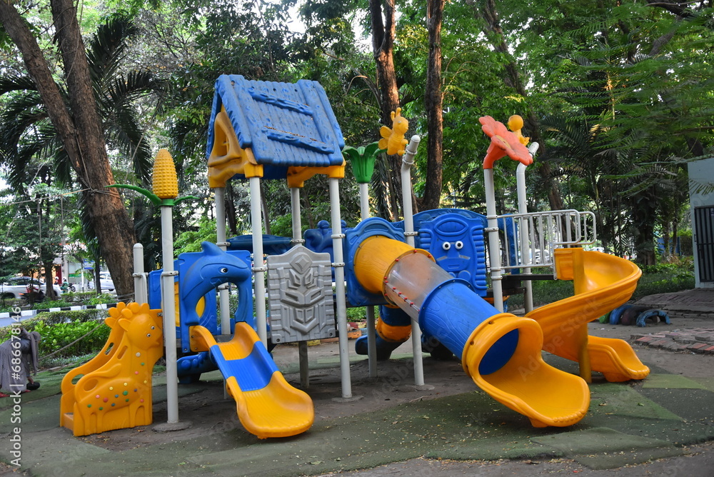Colorful children's playground on the lawn in the park. beautiful city green park with trees