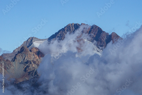 The Valtellina mountains shrouded in fog, taken from Val Madre, a small valley near the town of Colorina, Lombardy, Italy - 15 October 2023. photo