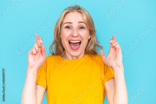 Fotografija Excited woman with crossed fingers and opened mouth