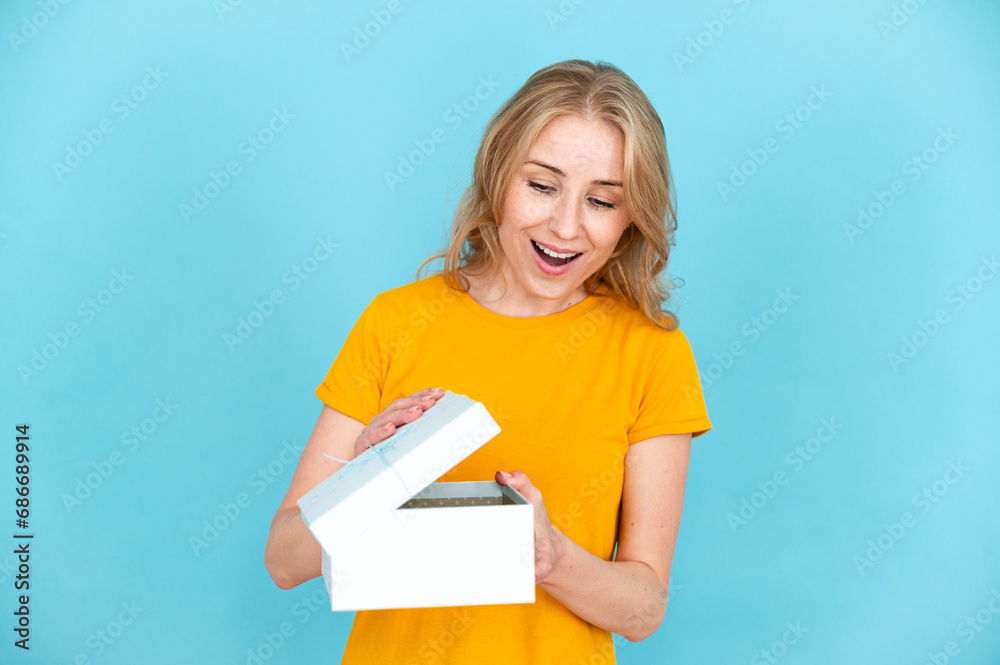 Wondered woman opening carefully box with present. Wondered woman opening carefully box with present.
