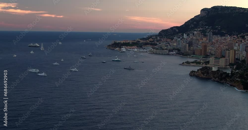 Aerial Tilt Up Shot Of Nautical Vessels In Sea By Residential City Against Sky During Sunset - Monte Carlo, Monaco