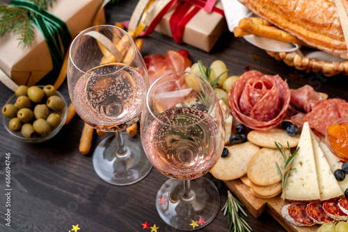 two glasses of champagne, Prosecco or rosé wine , festive aperitif or party with cold meat appetizers cheeses and olives