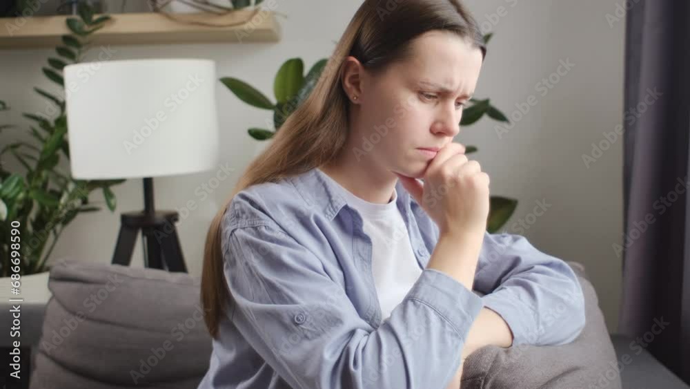 Close up of anxious tired young caucasian woman sitting on couch, feeling doubtful making difficult decision. Nervous unhappy lady 25s suffering from negative thoughts, relationship problems concept Close up of anxious tired young caucasian woman sitting on couch, feeling doubtful making difficult decision. Nervous unhappy lady 25s suffering from negative thoughts, relationship problems concept