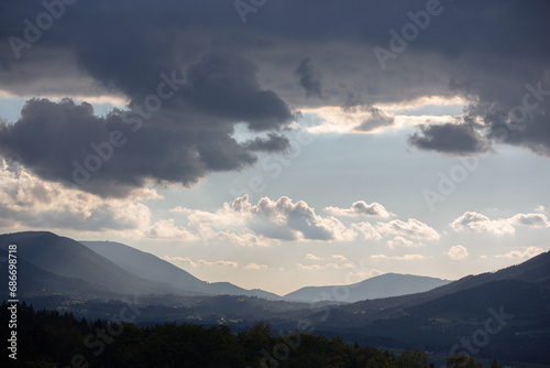 Clouds over the mountains and a valley in suspenseful lighting