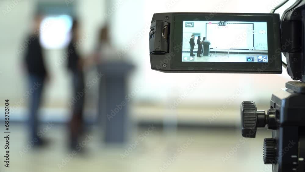 Professional video operator shooting video of business forum with speakers. Professional video operator shooting video of business forum with speakers.