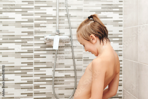 Cute child washing himself in shower.