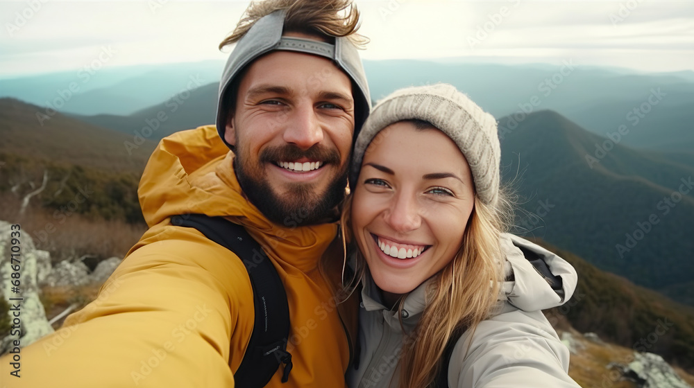 Young hiker couple taking selfie portrait on the top of mountain - Happy guy smiling at camera - Tourism, sport life style and social media influencer concept. Young hiker couple taking selfie portrait on the top of mountain - Happy guy smiling at camera - Tourism, sport life style and social media influencer concept.