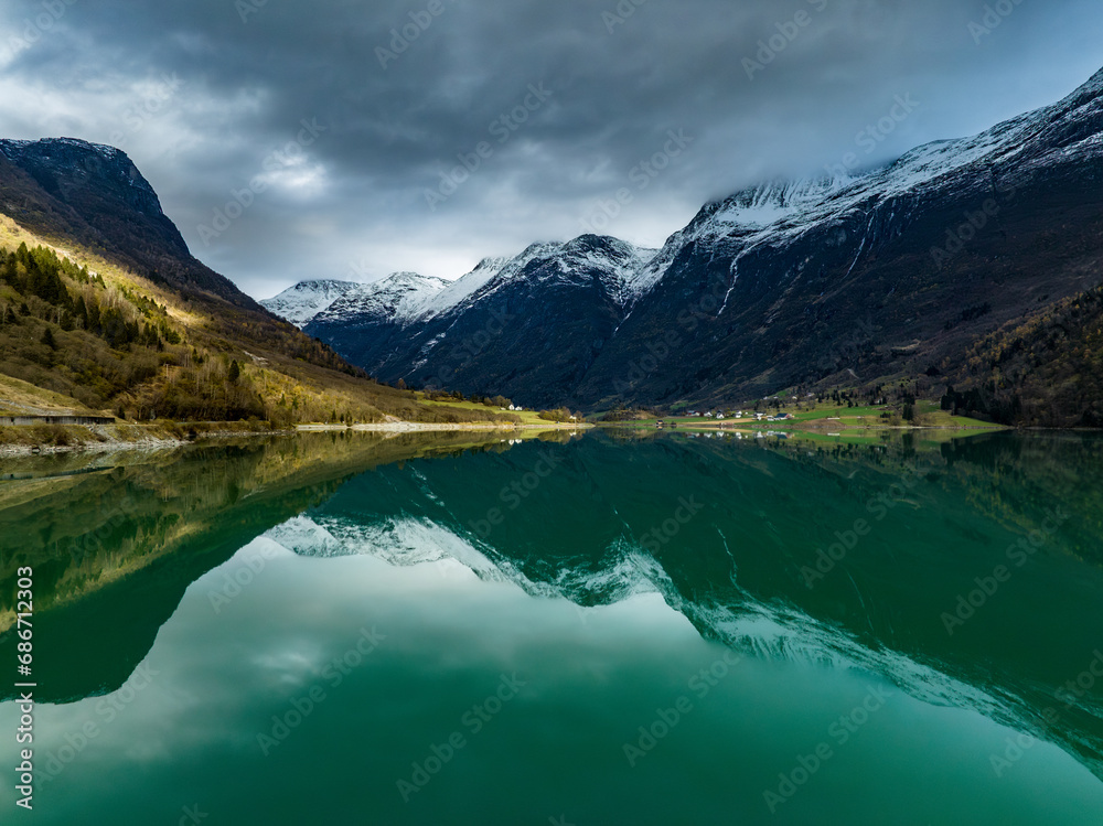 scenic norwegian landscape with mountains, cabin on shore of the cyan Oldevatn lake with reflections