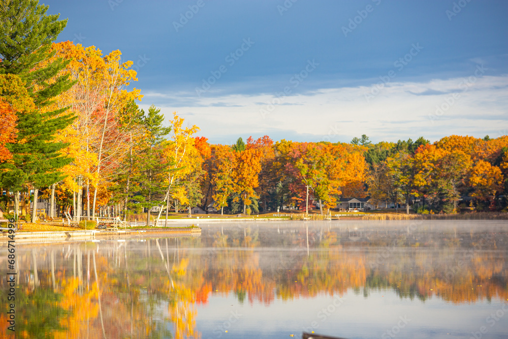 Obraz premium Extremely vibrant fall colors on trees at a lake in Michigan