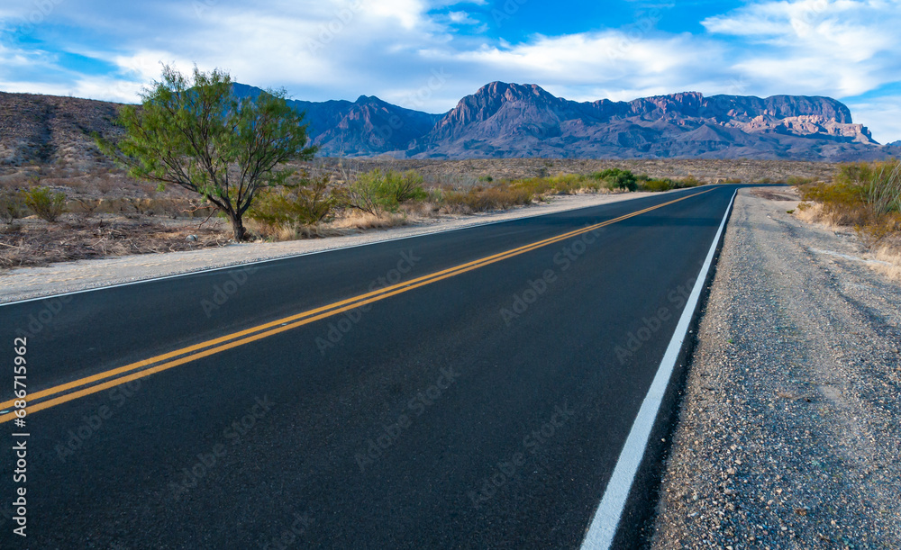 Smooth asphalt road in the Texas desert in Big Bend NP, landscape with mountains in the background