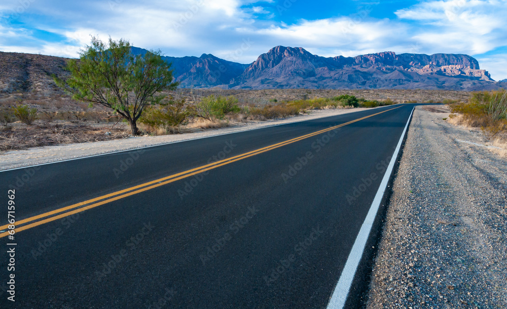 Smooth asphalt road in the Texas desert in Big Bend NP, landscape with mountains in the background Smooth asphalt road in the Texas desert in Big Bend NP, landscape with mountains in the background