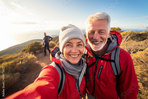 Senior couple taking a selfie while hiking in the mountains on a sunny day