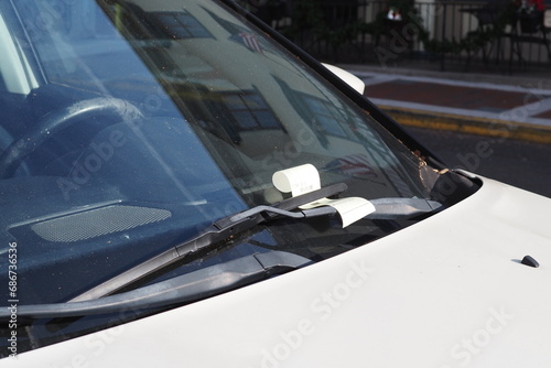 Their is a parking ticket under the windshield wiper. photo