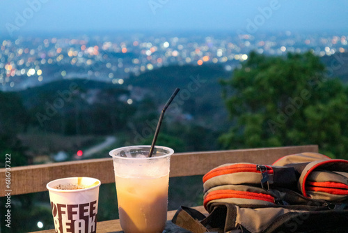 A cup of coffee and a backpack on the balcony in the evening.