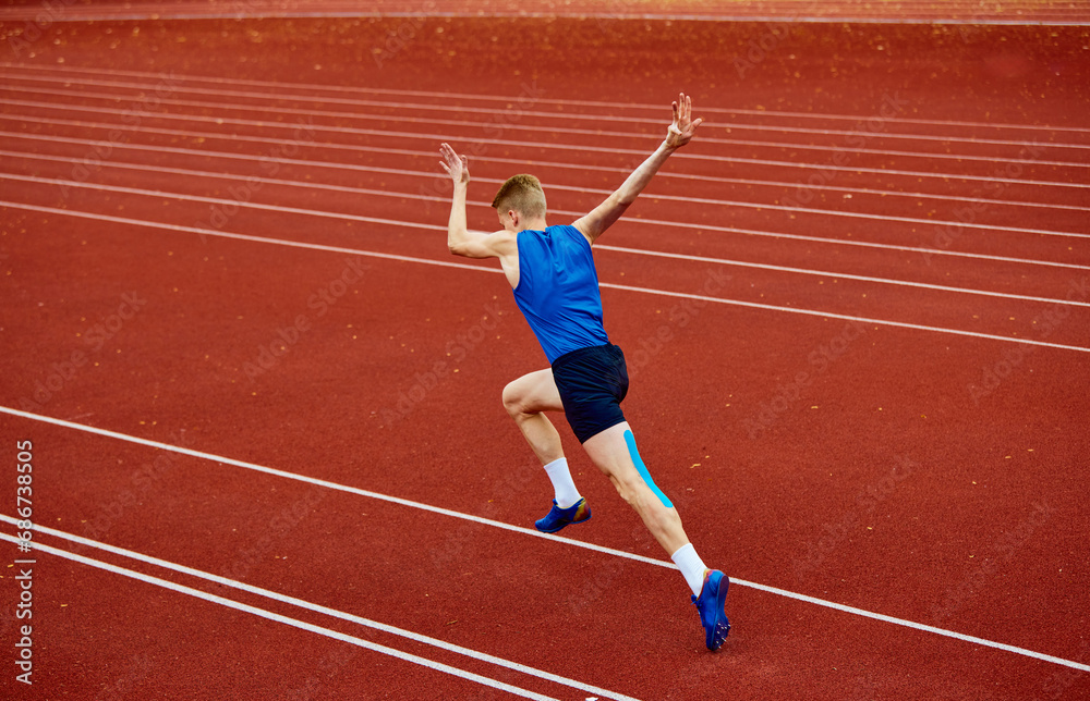 Obraz premium Swift runner cutting through the air with precision. Full length rear view portrait of man, professional sportsman fast running on sport field.