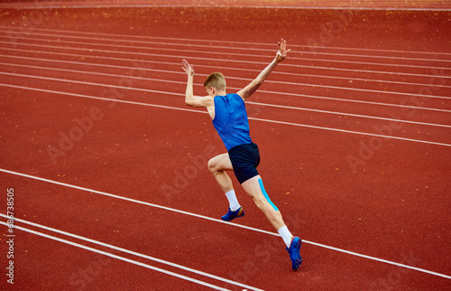 Swift runner cutting through the air with precision. Full length rear view portrait of man, professional sportsman fast running on sport field. photo